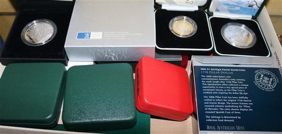 Twelve cased UK proof silver coins and a silver model of a pillar dollar